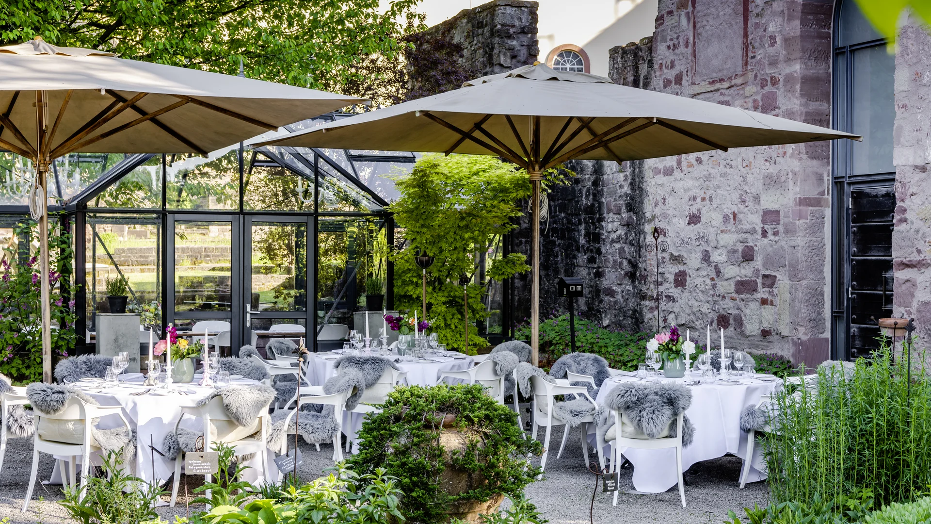 What’s a party without great food and the perfect drink? Elegant outdoor terrace with tables under umbrellas and decorative plants