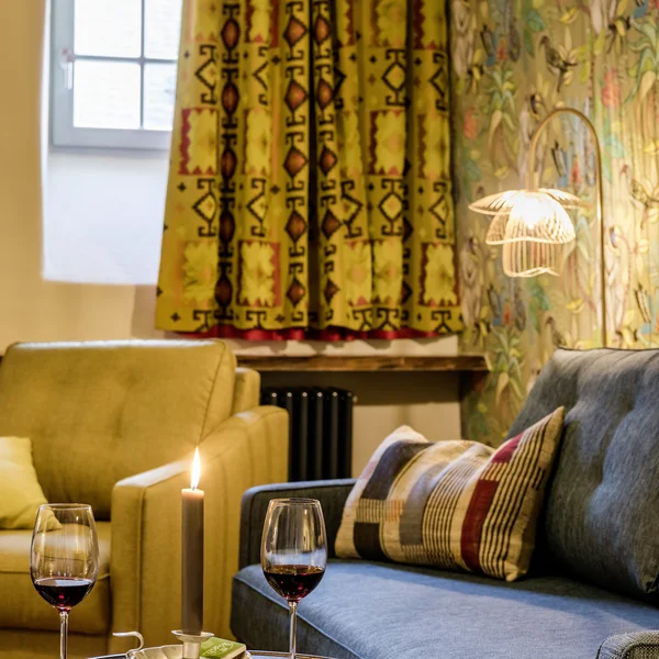 Inklusivleistungen im Kloster Hornbach und im Lösch Gemütliches Wohnzimmer mit zwei Sofas, Kerze, Wein und Dominosteinen auf Tisch