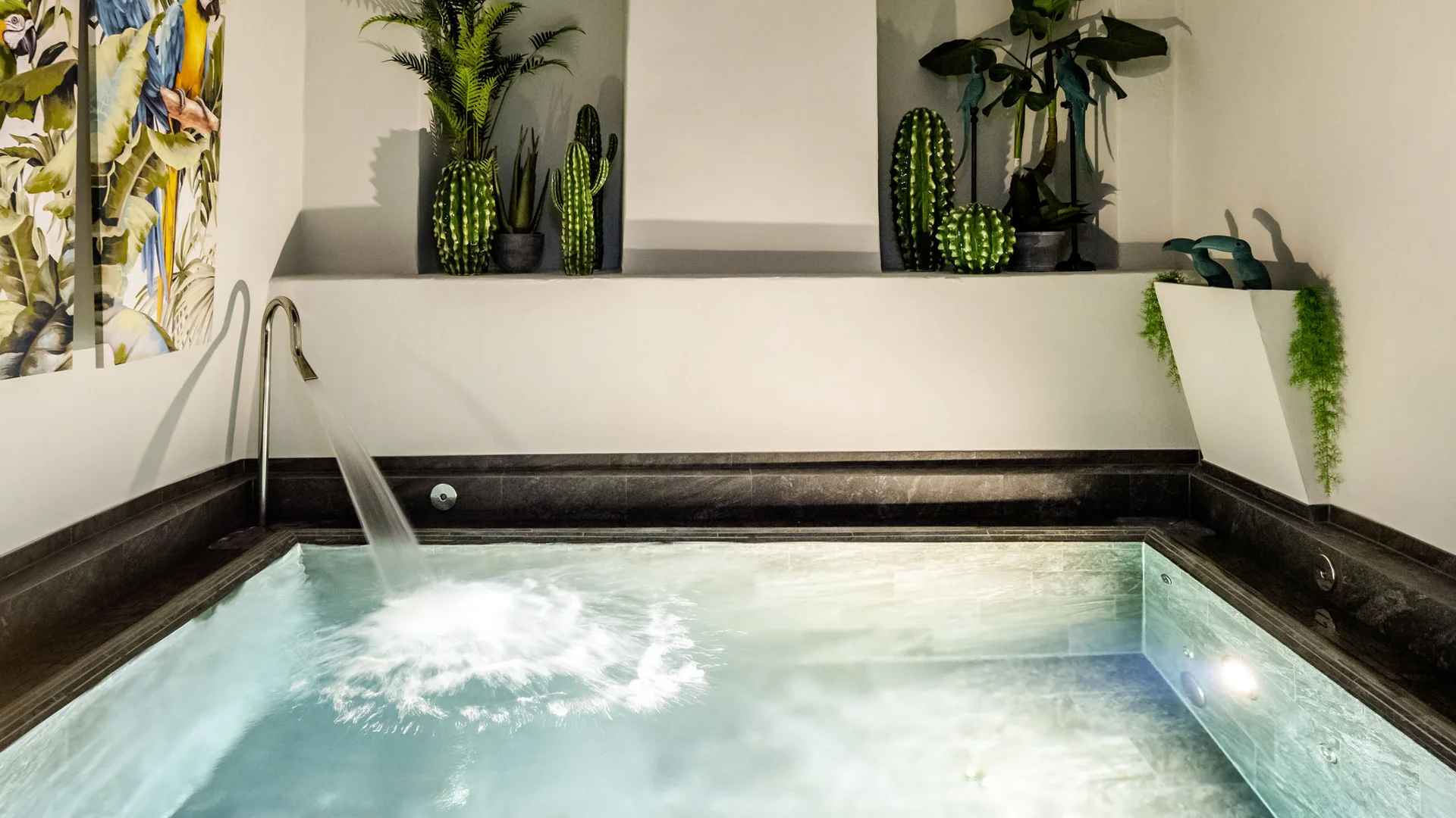 Wellness im Kloster in Deutschland Innenwhirlpool mit Wasserfall und grünen Pflanzen in modernem Raum