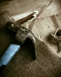 Kloster Hornbach: Ihre Ansprechperson für Medienanfragen Alter Hammer liegt auf sackartigem Stoff neben Holzbrett und Seil