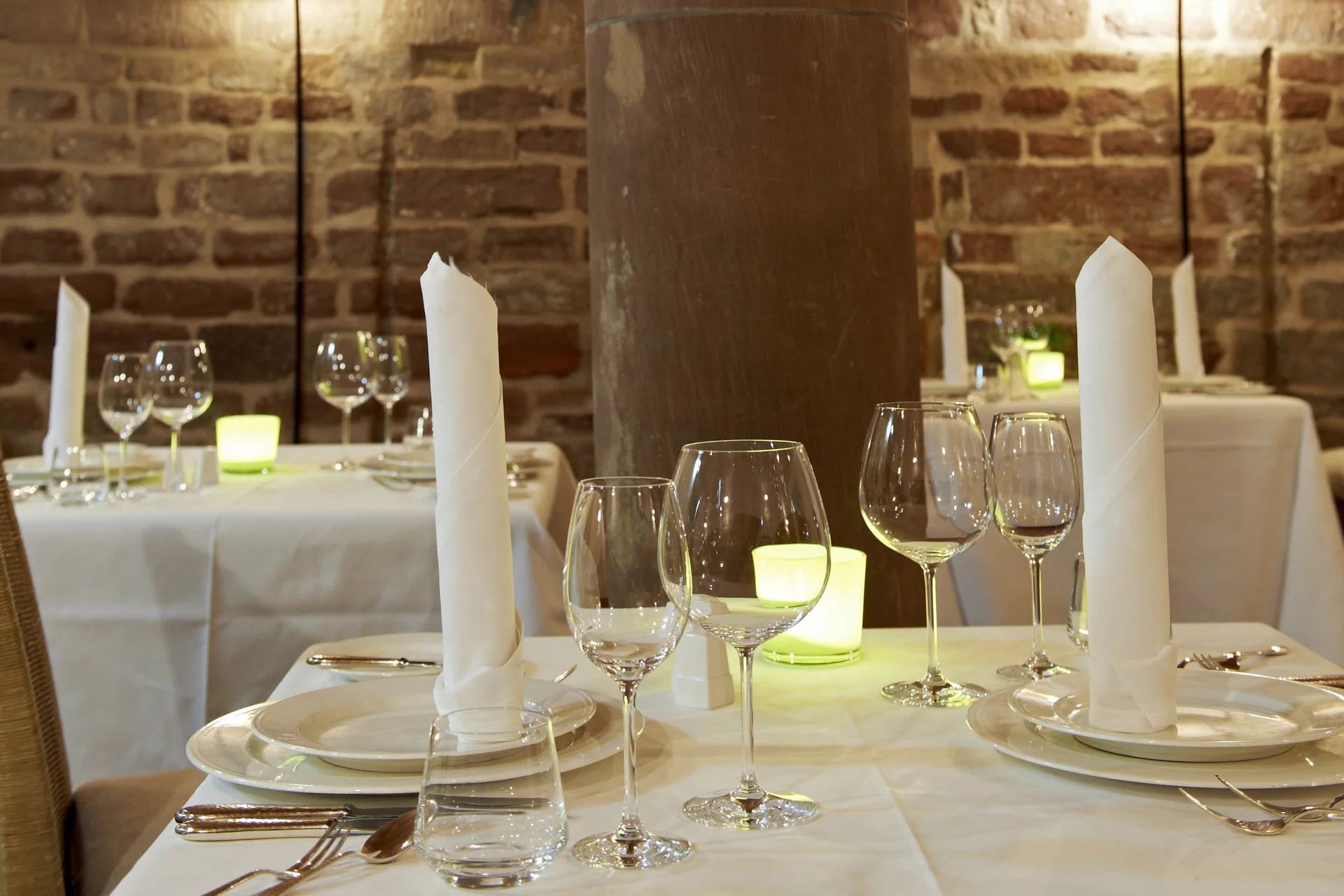 Säulenzimmer Elegantes Restaurant mit gedeckten Tischen und Steinpfeiler im Innenraum