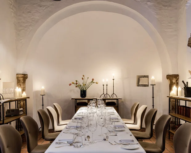 Räume für besondere Anlässe im Kloster Hornbach Eleganter Esstisch mit Kerzen in einem Raum mit weißem Bogen und Bücherregalen