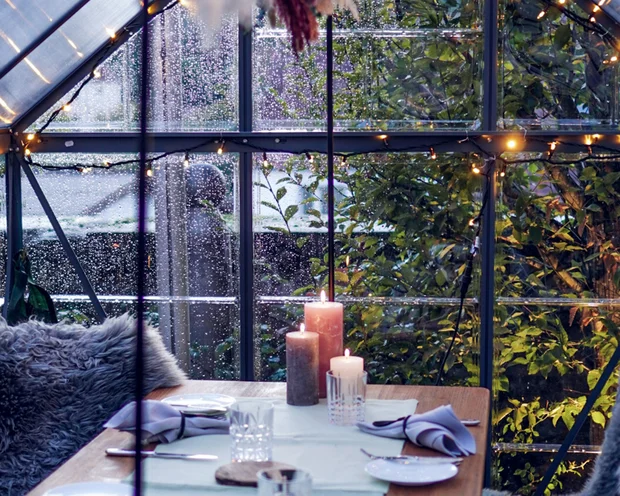 Räume für besondere Anlässe im Kloster Hornbach Gemütlich gedeckter Tisch in einem Glashaus mit Kerzen und Sitzkissen