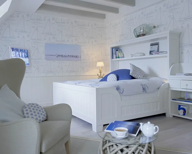 Wollen Sie das gesamte Landhaus mieten? Helles Schlafzimmer mit weißem Bett, blau-weißem Dekor und maritimem Muster