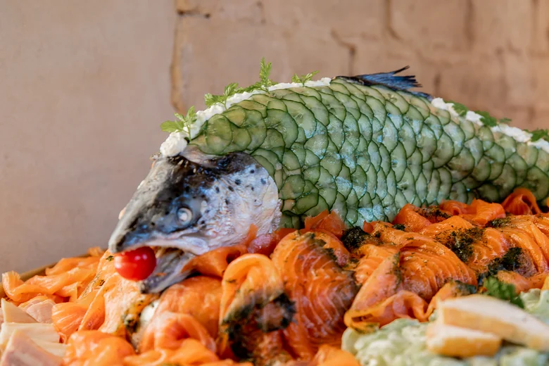 Sunday brunch Salmon platter with raw salmon and fish head decorated with cucumber slices