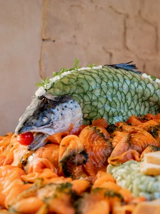 Treffpunkt, Kraftplatz und Hotel in Hornbach Lachsplatte mit rohem Lachs und dekoriertem Fischkopf mit Gurkenscheiben