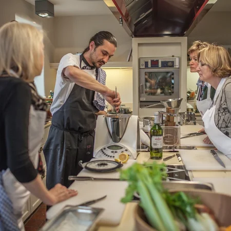 Veranstaltungen im Kloster Hornbach Koch demonstriert Kochtechnik vor einer Gruppe von Erwachsenen in einer Küche