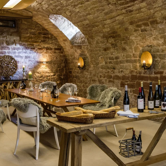 Inklusivleistungen im Kloster Hornbach und im Lösch Weinkeller mit rustikalem Holz, Fellen auf Stühlen und Weinflaschen auf einem Tisch