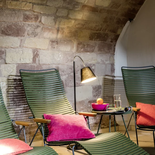 Treffpunkt, Kraftplatz und Hotel in Hornbach Grüne Liegestühle mit pinken Kissen und Lampe vor einer Steinwand