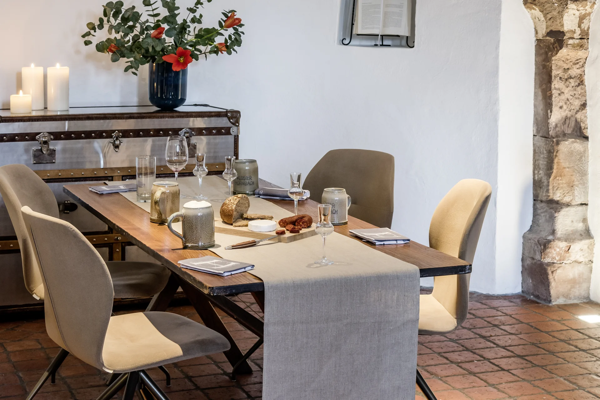 Kulinarik im Lösch: Gaumenfreuden der besonderen Art Moderner Essbereich mit Holztisch, beigen Stühlen und Kerzen in einem Raum mit Rundbogen
