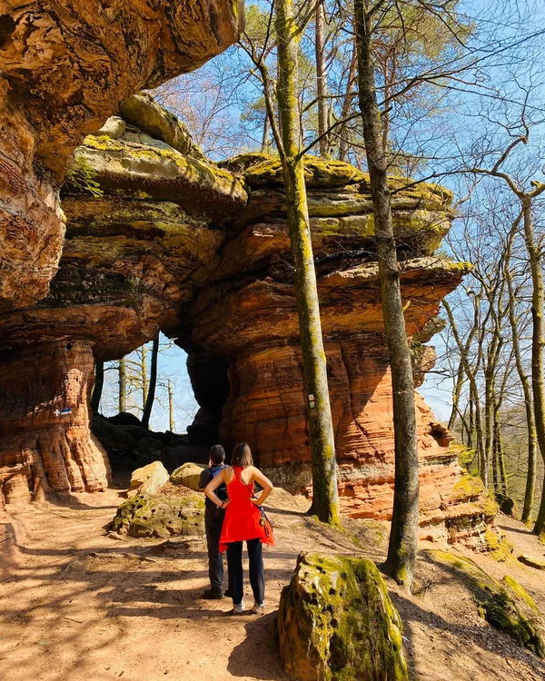Aktivurlaub in der Pfalz – Wandern, Radfahren und Golfen rund ums Kloster Hornbach und das Lösch Wanderer vor einem großen Felsen mit natürlichem Durchgang im Wald