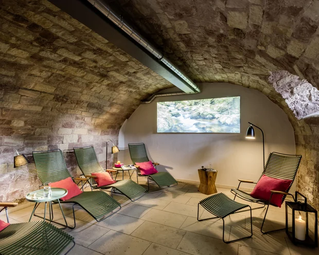 Treffpunkt, Kraftplatz und Hotel in Hornbach Entspannungsraum mit grünen Liegestühlen und roten Kissen in einem Gewölberaum