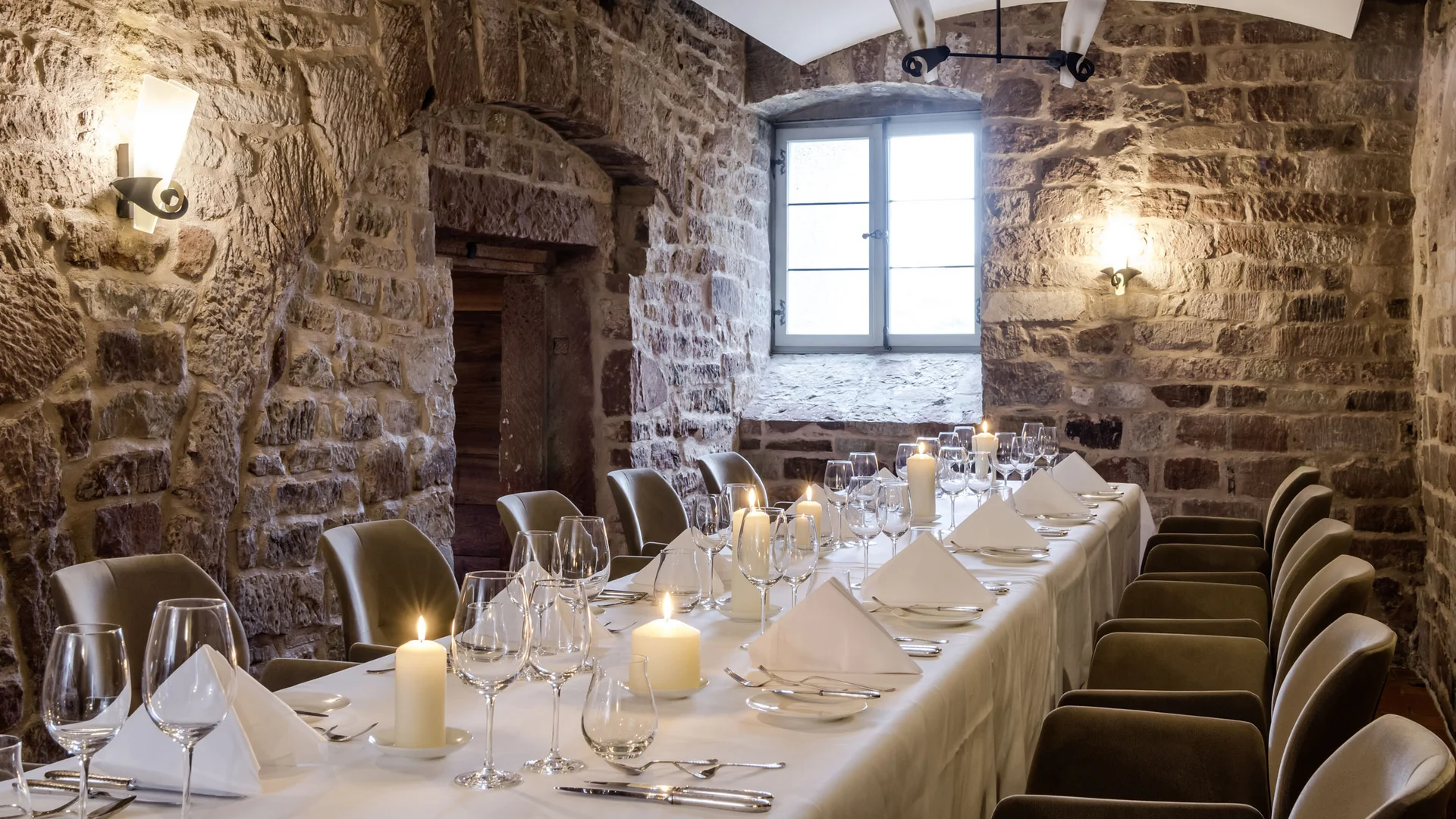 Von gemütlich bis Gourmet: Restaurants im Kloster Hornbach Eleganter Essraum mit Steinwänden und Kerzen auf einem gedeckten Tisch