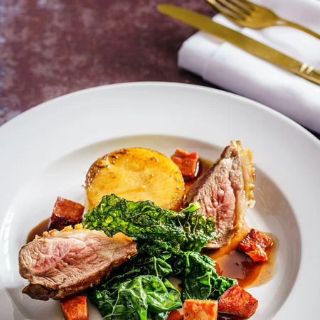 Veranstaltungen im Kloster Hornbach Elegantes Gericht mit rosa gebratenem Fleisch, Blattgemüse, Kartoffel und Würfeln