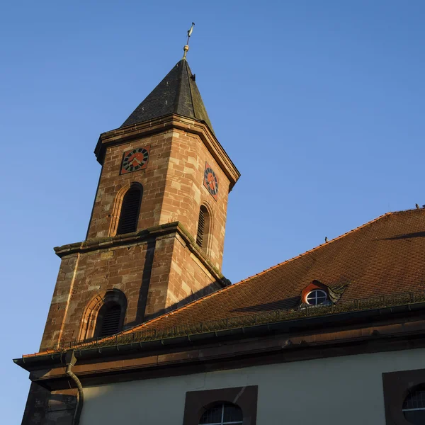 Exzellenter Lernort Kloster Hornbach Kirchturm aus Stein mit Uhr und spitzem Dach bei klarem Himmel