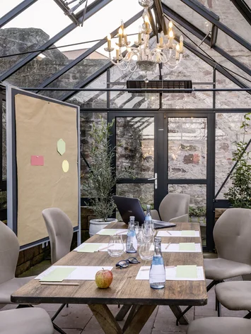 Tagungsräume Pfalz | Historische & moderne Räume im Kloster Hornbach Konferenzraum im Gewächshaus mit Holztisch und beigen Stühlen