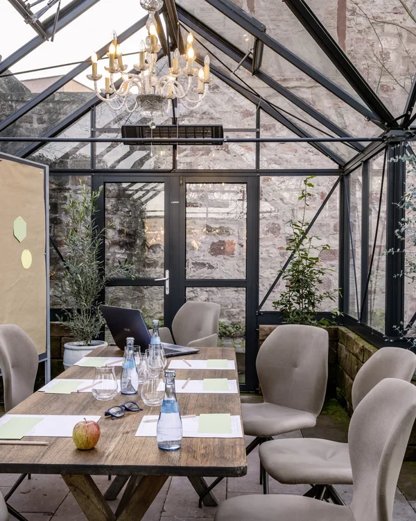 Ihr Tagungshotel Pfalz | Kreative Meetings im historischen Kloster Hornbach Konferenzraum im Gewächshaus mit Holztisch und beigen Stühlen