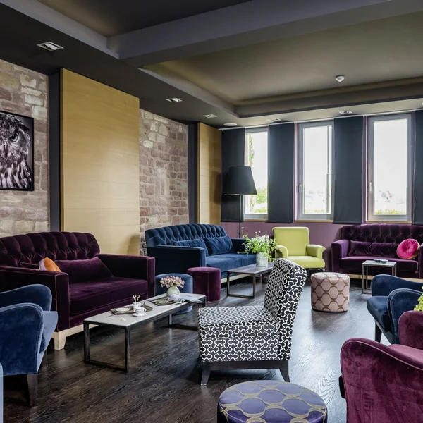 Wollen Sie das gesamte Landhaus mieten? Gemütlicher Lounge-Bereich mit farbigen Sesseln, Sofas und Hockern in modernem Stil