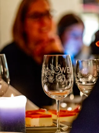 Treffpunkt, Kraftplatz und Hotel in Hornbach Gläser und Kerze auf einem Tisch bei einem Abendessen mit unscharfen Personen im Hintergrund