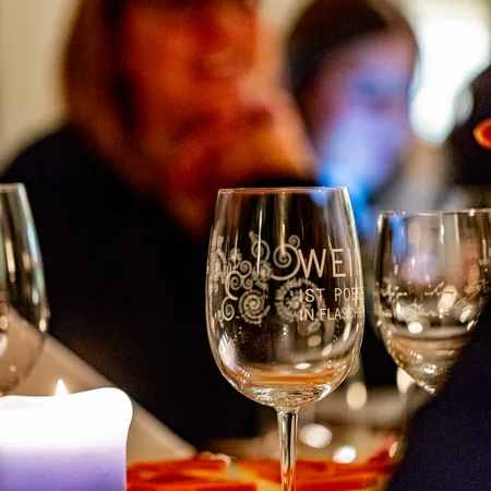 Veranstaltungen im Kloster Hornbach Gläser und Kerze auf einem Tisch bei einem Abendessen mit unscharfen Personen im Hintergrund