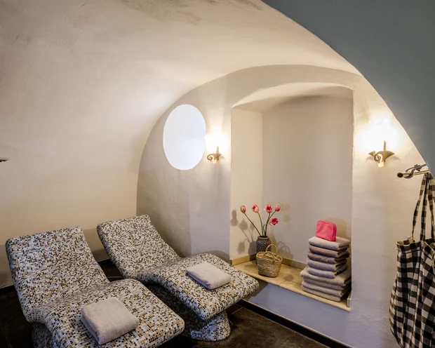 Wellness im Kloster in Deutschland Ruhezone mit zwei Liegestühlen, Handtüchern und Blumen in einem weißen Raum