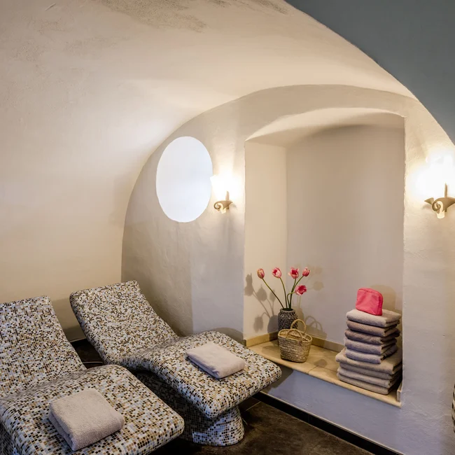 Treffpunkt, Kraftplatz und Hotel in Hornbach Ruhezone mit zwei Liegestühlen, Handtüchern und Blumen in einem weißen Raum