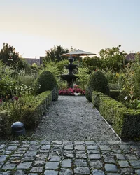 Kloster Hornbach: Ihre Ansprechperson für Medienanfragen Wege und Hecken in einem Garten mit einer Brunnenanlage und Blumenbeeten