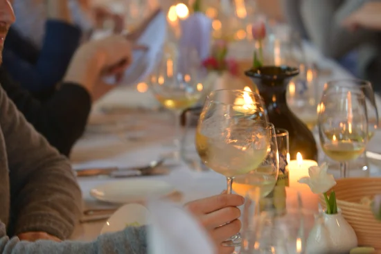 ABBA-Dinner – A Night to Remember Menschen sitzen an einem langen Tisch mit wein und Kerzenlicht