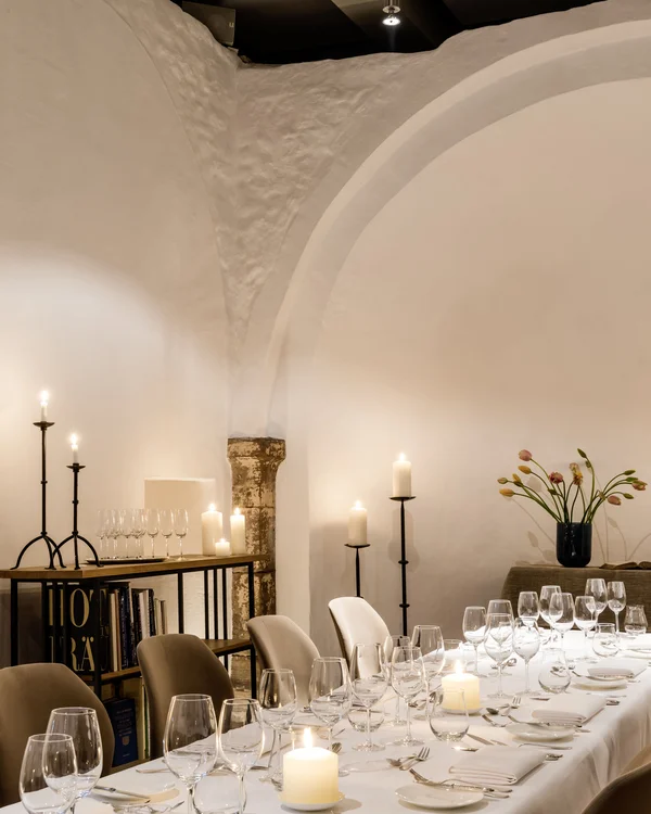 Räume für besondere Anlässe im Kloster Hornbach Eleganter gedeckter Esstisch mit Kerzen und Weingläsern in einem Raum mit Bogenwänden