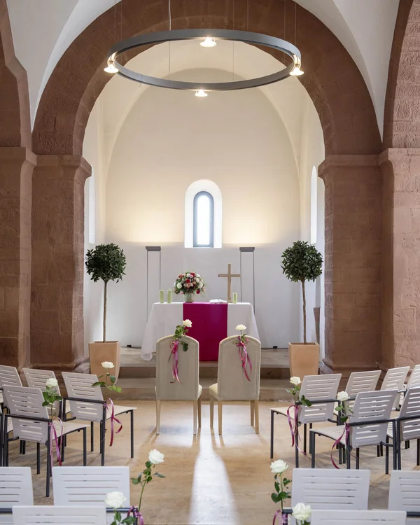 Freie Trauung in der Traumlocation in Rheinland-Pfalz Innenansicht einer Kirche mit dekorierten Stühlen und Altar für Hochzeit