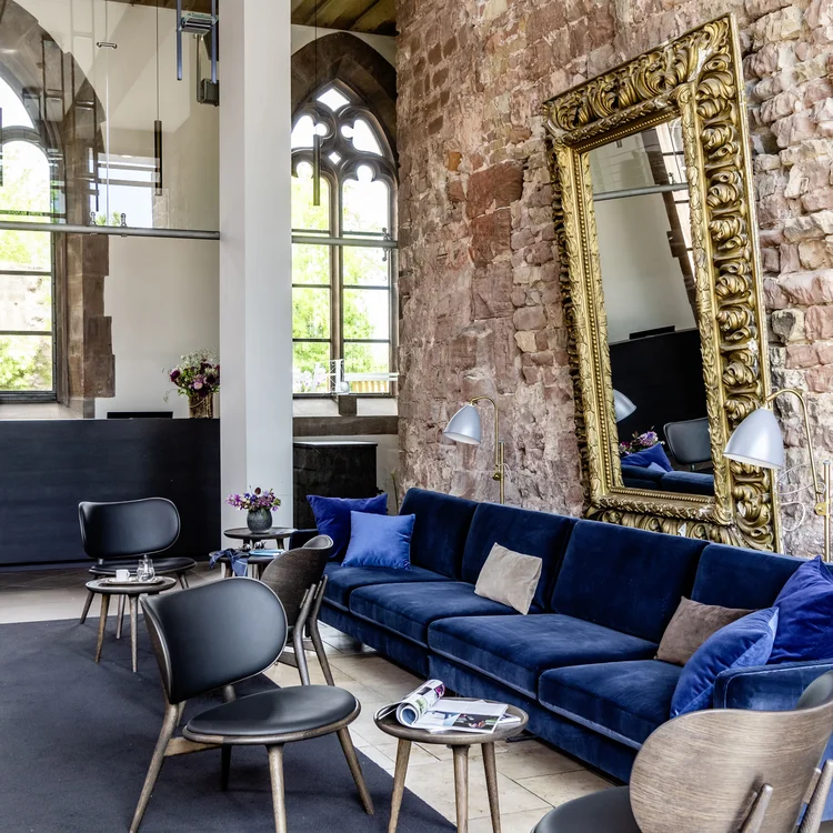 Treffpunkt, Kraftplatz und Hotel in Hornbach Moderner Wartebereich mit blauer Couch, Stühlen und großer verzierten Spiegelwand