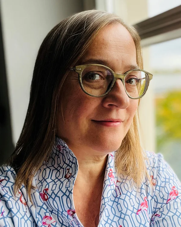 Kloster Hornbach: Ihre Ansprechperson für Medienanfragen Frau mit Brille und floral gemustertem Hemd vor Fenster