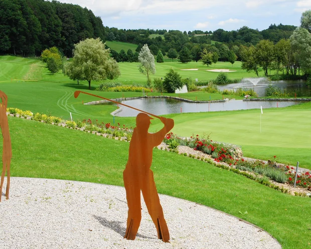 Ausflugstipps für Ihren Urlaub in der Pfalz Golfschläger Skulpturen auf einem gepflegten Golfplatz mit Teich und Bäumen