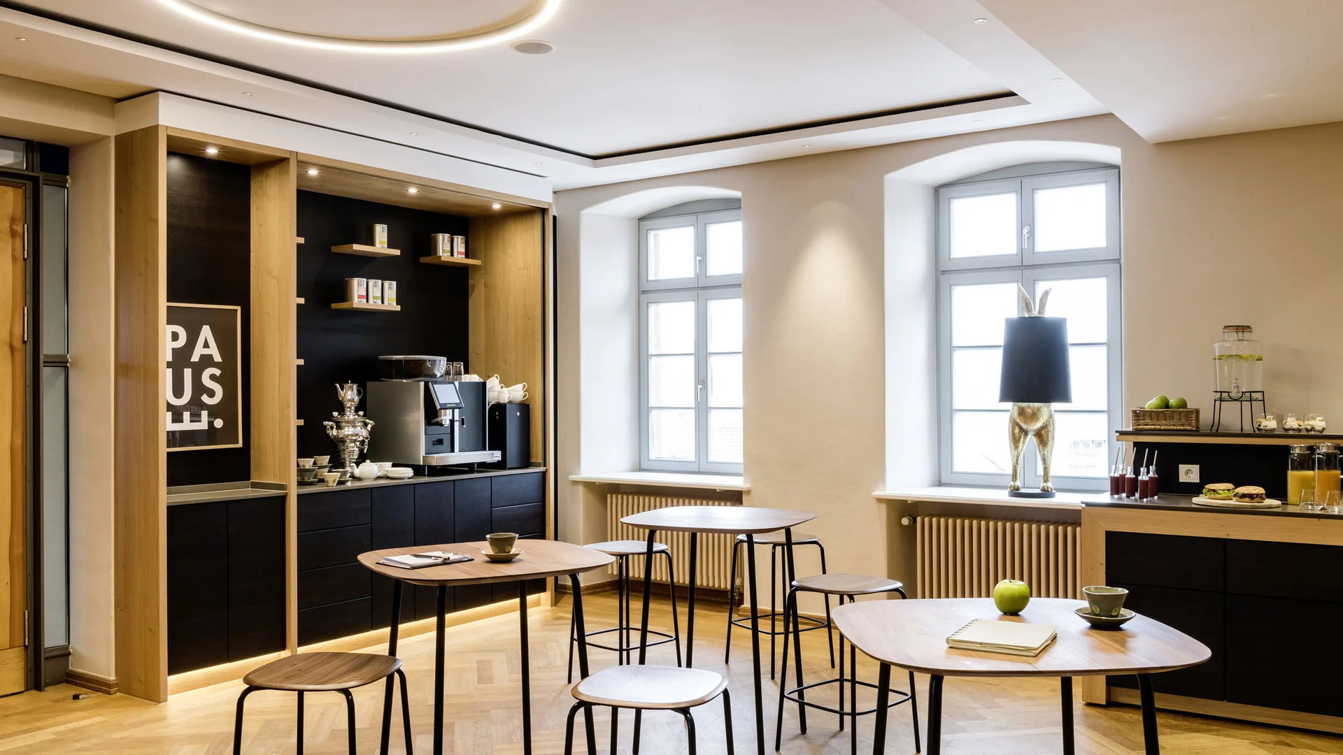 Ihr Seminar im Tagungshotel mit Rahmenprogramm Modern eingerichteter Aufenthaltsraum mit Stehtischen, Kaffeemaschine und Dekoration