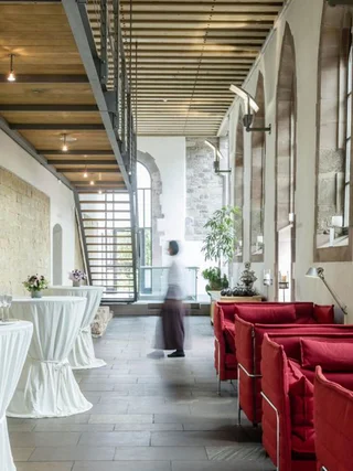 Treffpunkt, Kraftplatz und Hotel in Hornbach Moderne Lounge mit roten Sofas und Stehtischen in historischem Gebäude