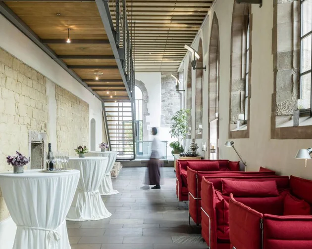 Treffpunkt, Kraftplatz und Hotel in Hornbach Moderne Lounge mit roten Sofas und Stehtischen in historischem Gebäude