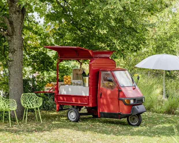 Our venue, your dream wedding Red three-wheeled food cart with lemons and glasses in garden under green tree
