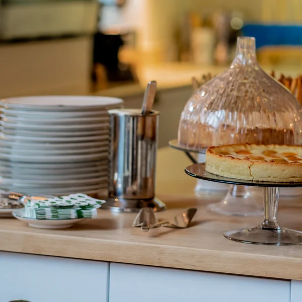 Inklusivleistungen im Kloster Hornbach und im Lösch Kuchen auf Glasständer mit Tellern und Besteck auf Holztisch in Küche