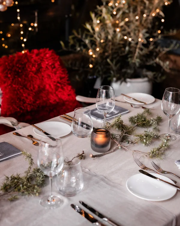 Weihnachten im Kloster Hornbach Festlich gedeckter Tisch mit Kerze, Gläsern und rotem Kissen im Hintergrund