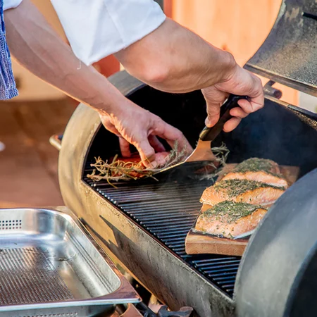 Veranstaltungen im Kloster Hornbach Person legt Lachsfilets mit Kräutern auf einen Grill
