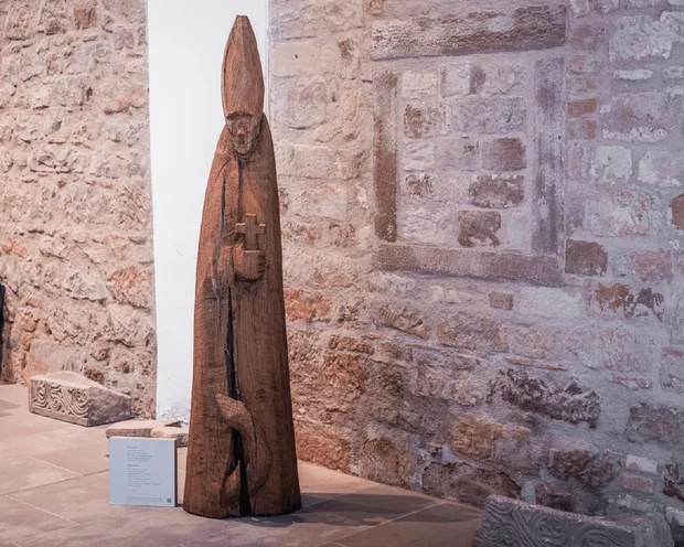 Ihre Gastgeber im Kloster Hornbach Holzfigur eines bischöflichen Heiligen mit Kreuz in einem Museum
