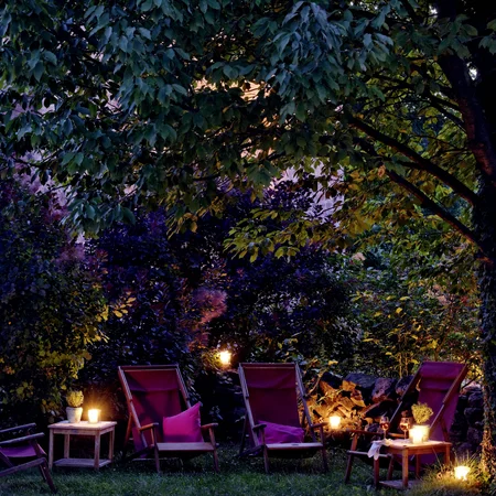 Veranstaltungen im Kloster Hornbach Abendliche Gartenbeleuchtung mit Stühlen und Kerzen unter einem Baum