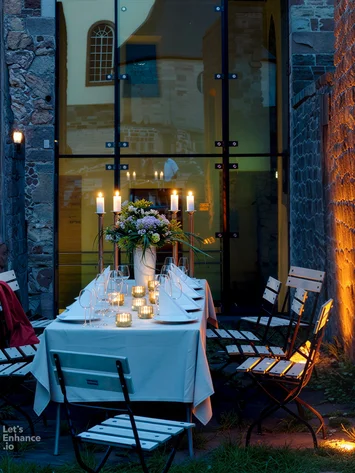 Our venue, your dream wedding Outdoor evening dining with candles and decorated table in courtyard