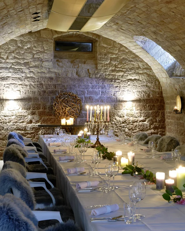 Wollen Sie das gesamte Landhaus mieten? Eleganter Kerzenschein gedeckter Tisch in einem steinernen Gewölbekeller