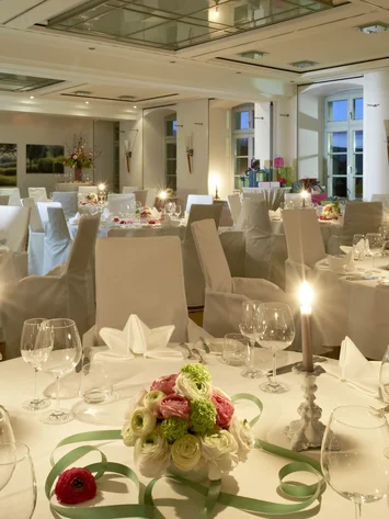 Our venue, your dream wedding Elegant banquet hall with festively set tables and floral centerpieces