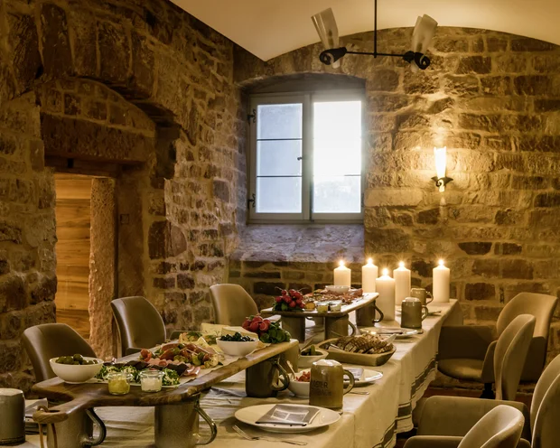 Our venue, your dream wedding Cozy dining room with rustic stone walls and a table set with candles