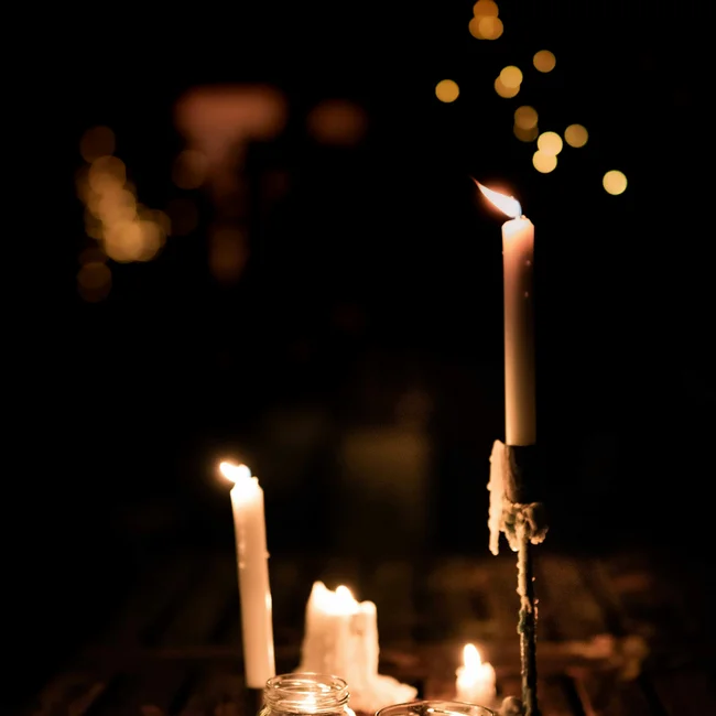 Treffpunkt, Kraftplatz und Hotel in Hornbach Brennende Kerzen auf Holztisch mit verschwommenen Lichtern im Hintergrund