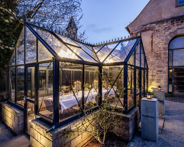 Räume für besondere Anlässe im Kloster Hornbach Beleuchtetes Glashaus mit festlich gedecktem Tisch im Abendlicht
