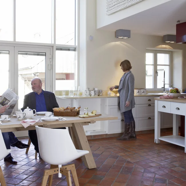 Inklusivleistungen im Kloster Hornbach und im Lösch Drei Personen beim Frühstück in einer modernen, hellen Küche mit großem Fenster