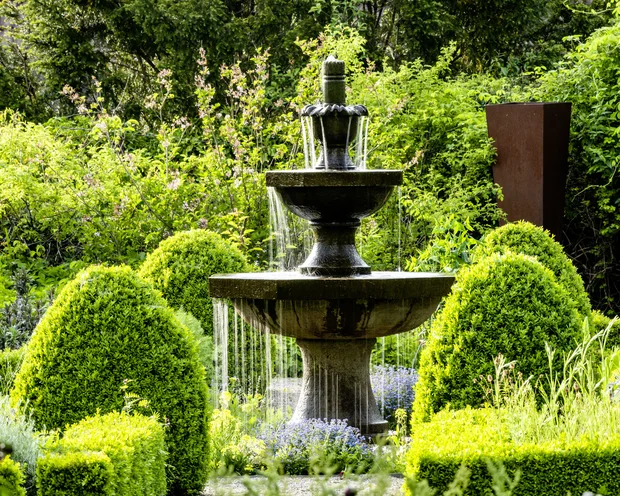 Treffpunkt, Kraftplatz und Hotel in Hornbach Steinbrunnen mit Wasser im gepflegten grünen Garten